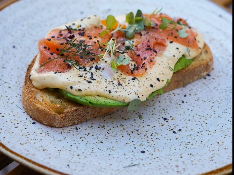 Benedict de la casa con salmón, aguacate y holandesa sobre pan de masa madre