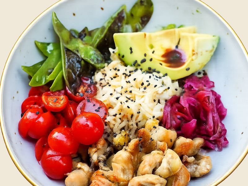 Bowl de pollo salteado con arroz, guisantes y aguacate