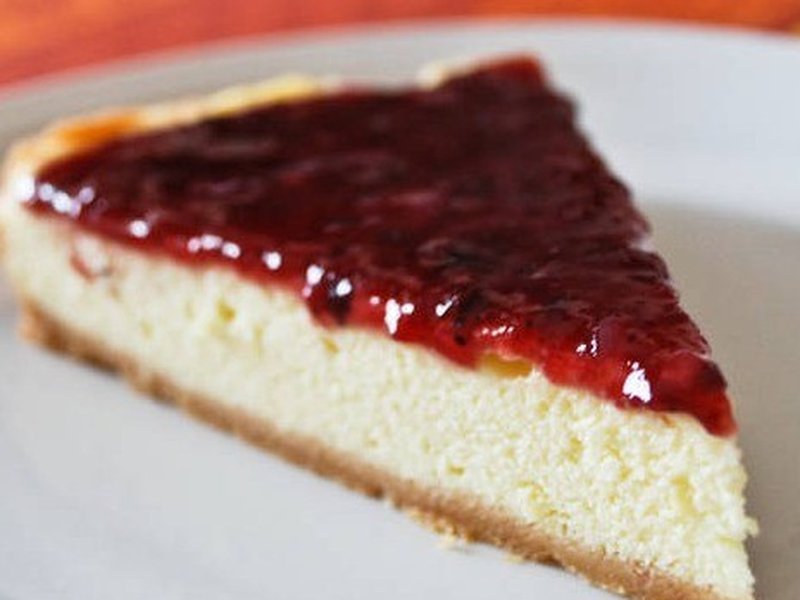 Porción de cheesecake vegano con coulis de fresas