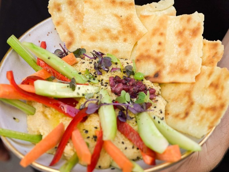 Hummus con coulis de granada, dukkah y crudités de verduras