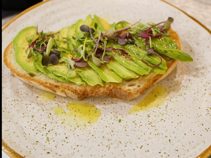 Tostada de aguacate con brotes sobre pan de masa madre tostado